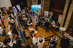 Blick von oben auf das Foyer in der Industrie- und Handelskammer. Viele Ausstellungsstände sind gut besucht.